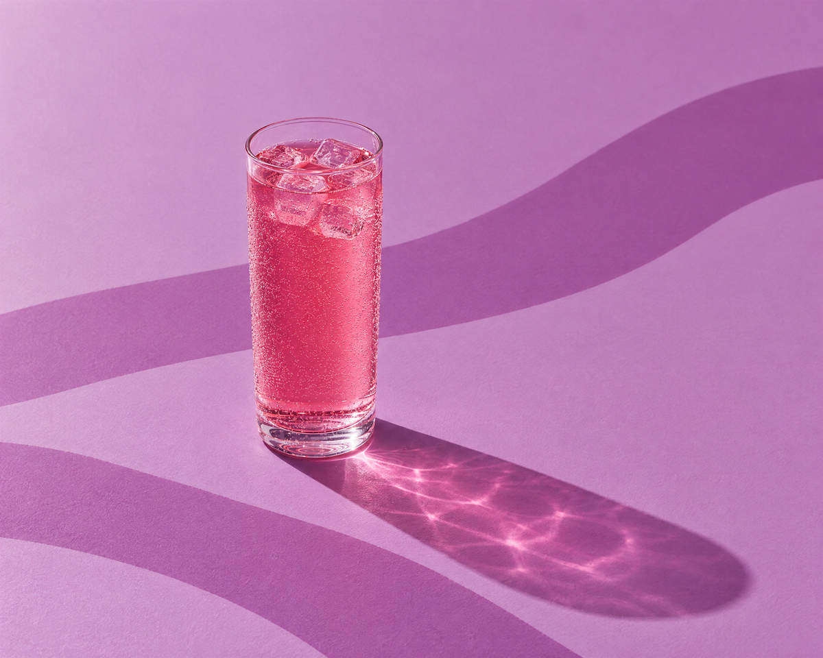 Un verre de boisson pêche cassis au collagène, avec des glaçons
