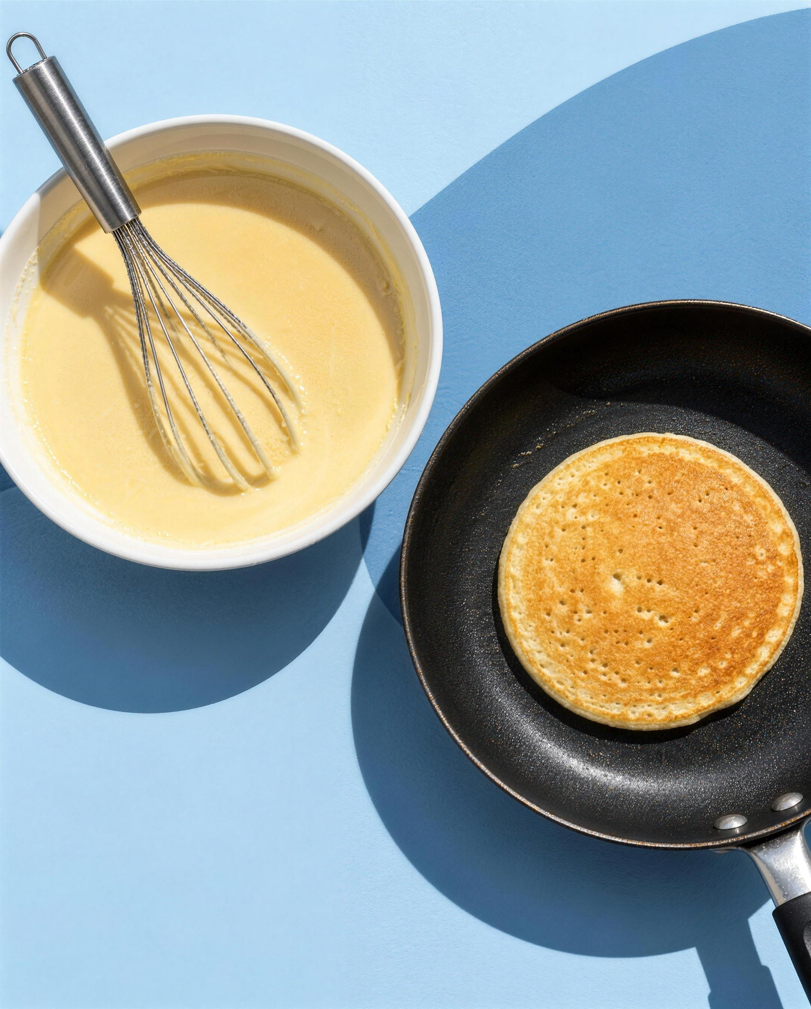 Un bol de pâte et un pancake qui cuit à la poêle